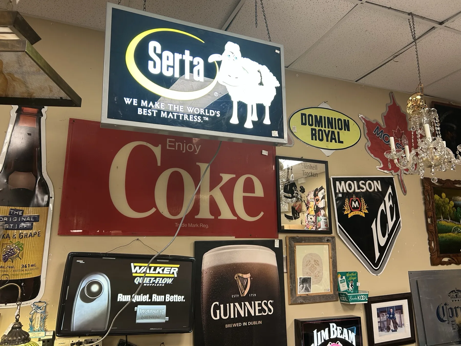 Wall of vintage Serta, Coke, Molson, Guinness and Dominion Royal signs at Krave Antiques Regina